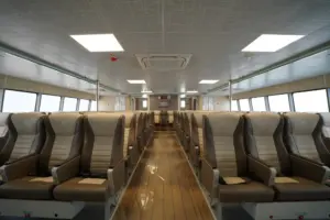 Passenger seats inside Ashi Ferry with large windows and wooden flooring.