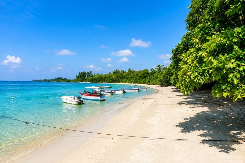 Bharatpur Beach at Neil Island, Andaman, with clear turquoise water, white sand, coral reefs, and tropical scenery.