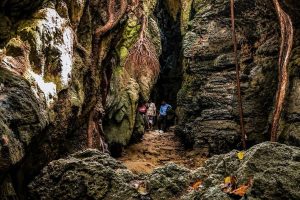 Exploring the narrow limestone cave passage in Andaman with tourists.