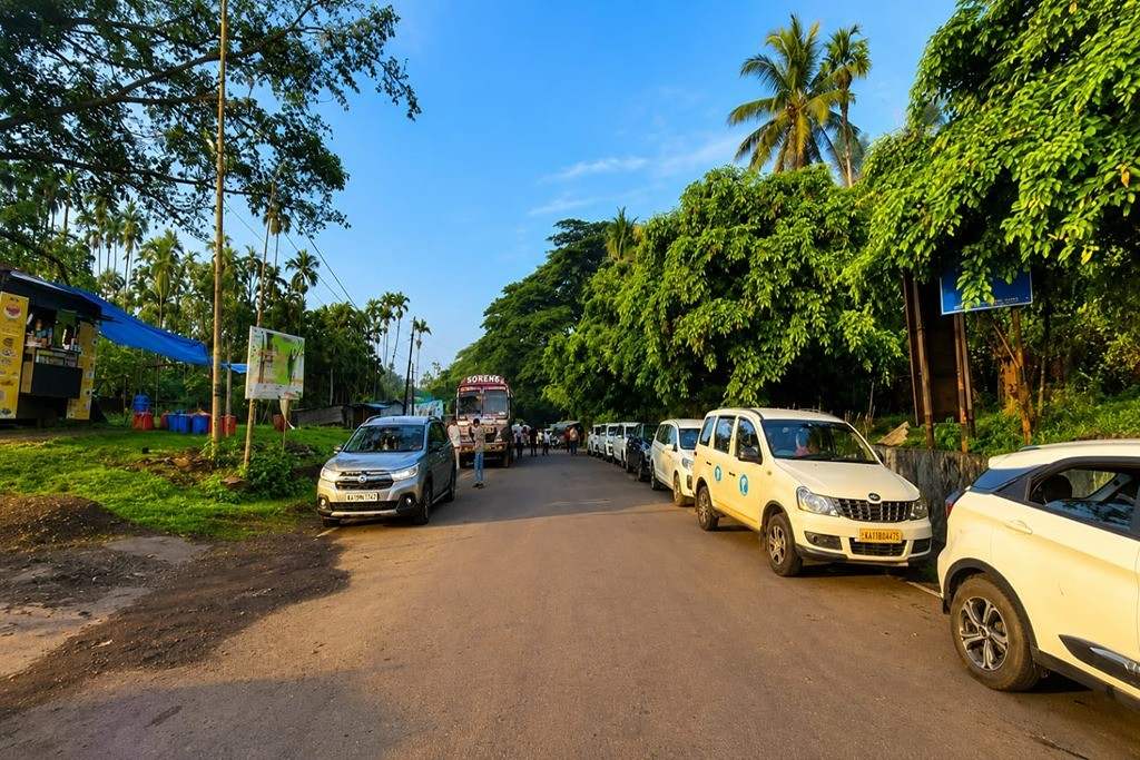Scenic road with parked cars and lush greenery in Andaman Islands.