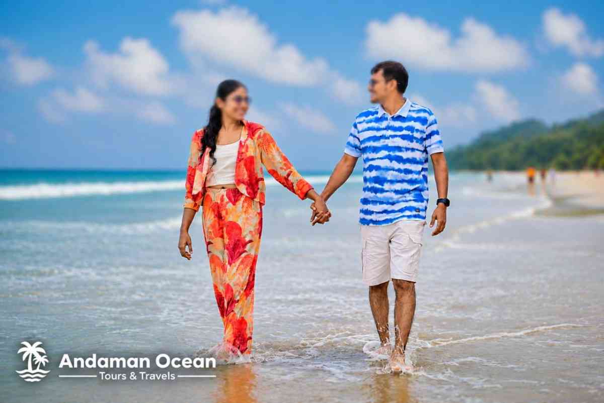 Happy couple walking hand in hand on the beach in Andaman with clear blue sky.