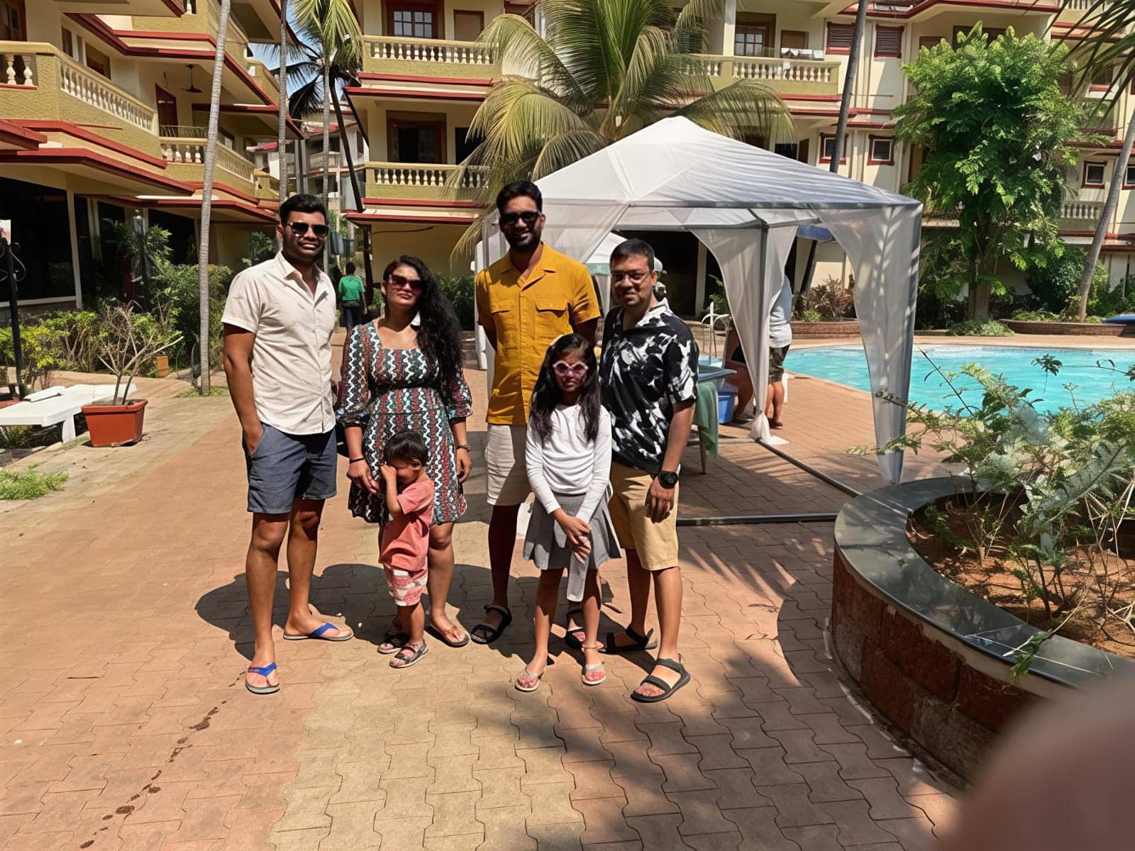 Family enjoying vacation at Andaman Ocean Resorts with pool and tropical surroundings.