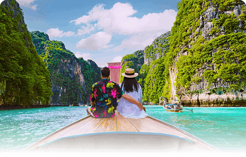 Couple enjoying boat ride through scenic Andaman Islands with lush green cliffs.