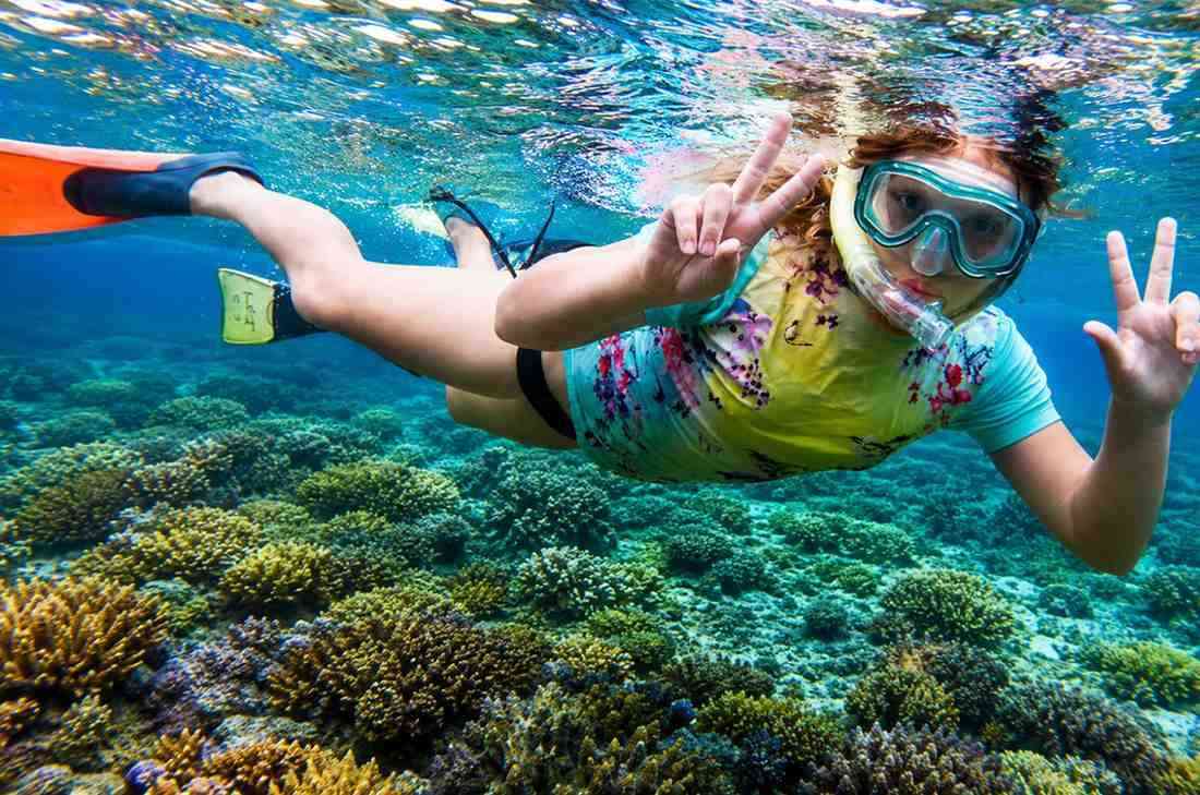 Family enjoying snorkeling in the crystal-clear waters of the Andaman Islands, exploring colorful coral reefs and tropical marine life.
