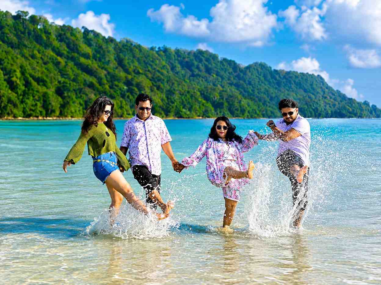 Happy friends and family from Tamil Nadu enjoying the turquoise waters at Havelock Island during their Andaman family tour with Andaman Ocean Tours & Travels.