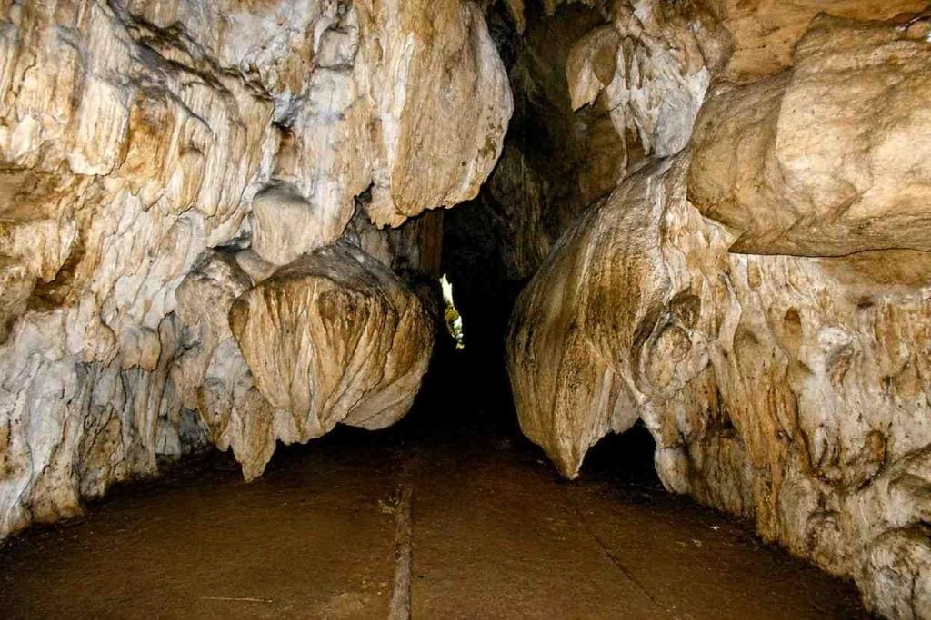 Cave entrance in Andaman with rugged rocks and narrow passage.