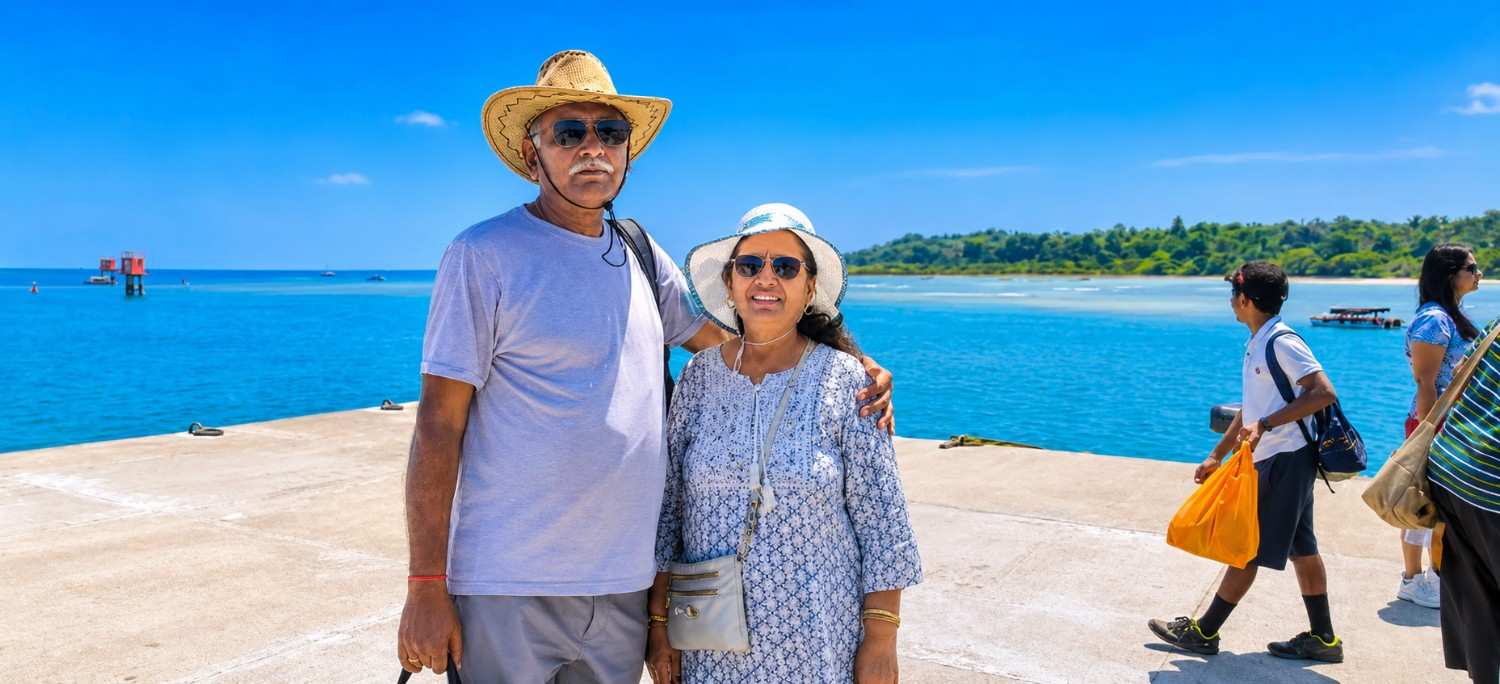 Happy senior citizen couple enjoying a relaxing beach holiday during their Andaman tour package with Andaman Ocean Tours & Travels.