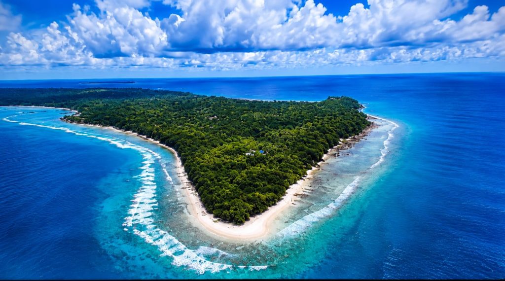 Aerial view of a lush green island surrounded by blue ocean waters.