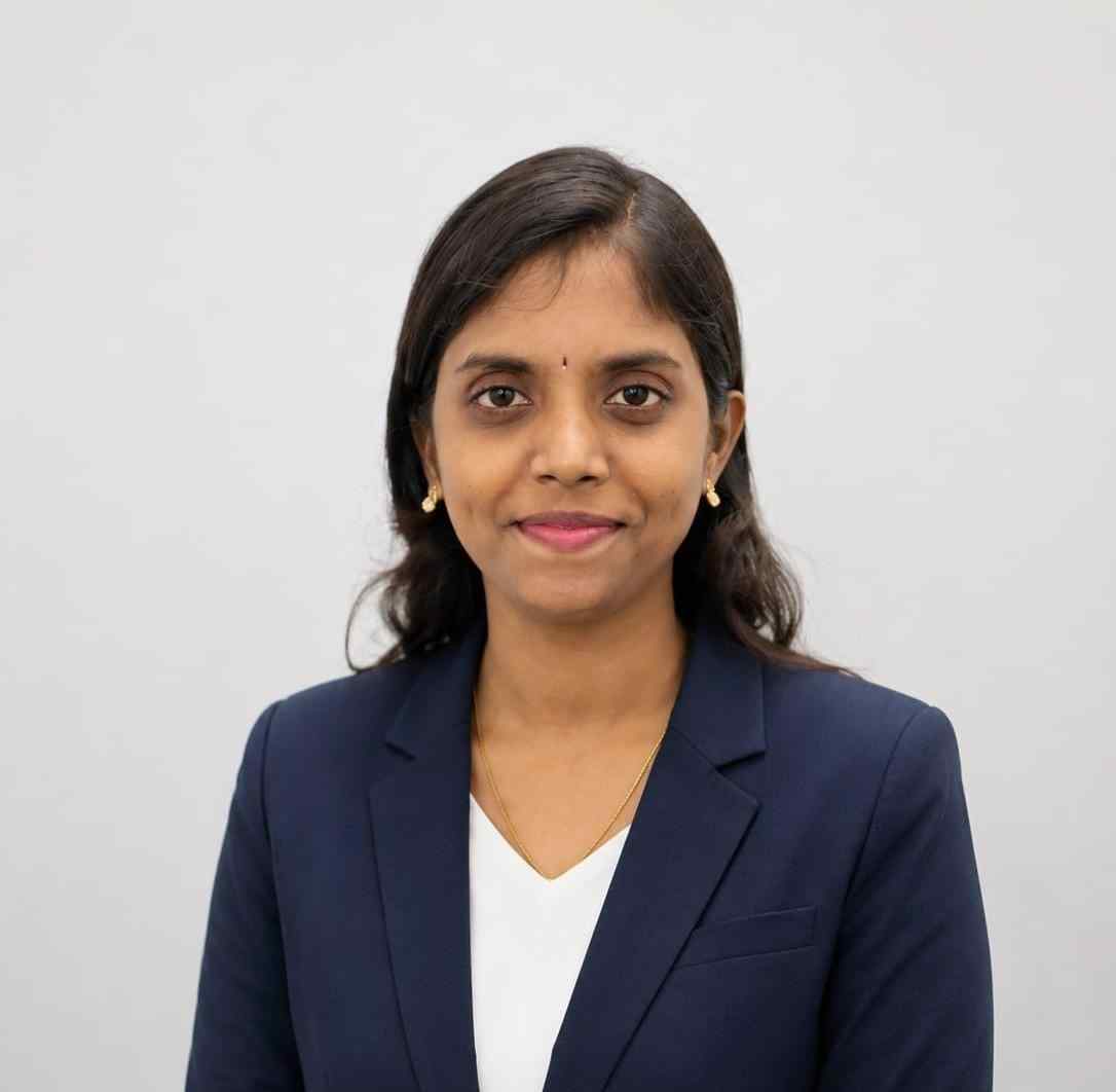 Businesswoman in navy blazer with white top, smiling confidently.