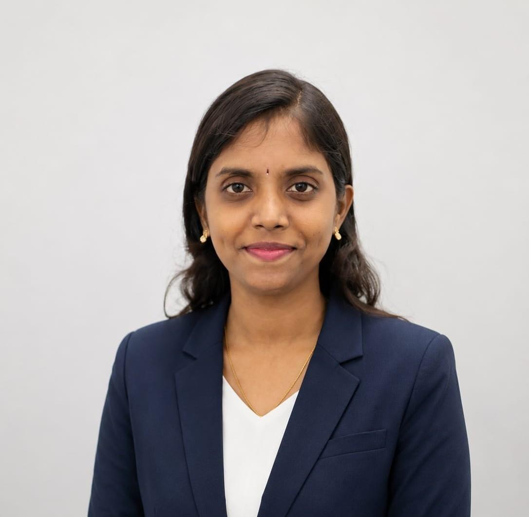 Businesswoman in formal navy blazer and white top, smiling confidently.