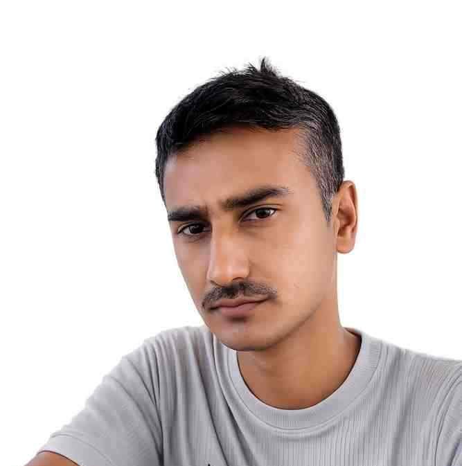 Young man with short black hair and mustache wearing a gray t-shirt and gold watch.