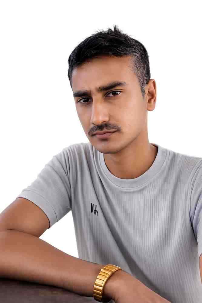 Young man with short black hair and mustache wearing a gray t-shirt and gold watch.
